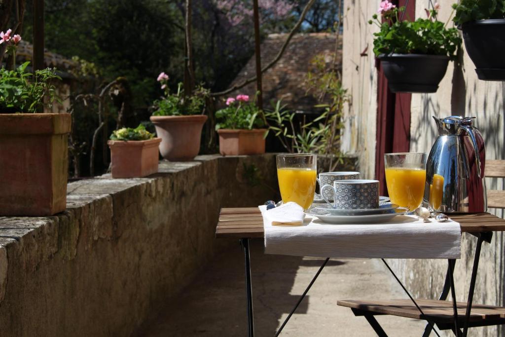 a table with two glasses of orange juice on it at L'Ancien Couvent Cahuzac in Cahuzac