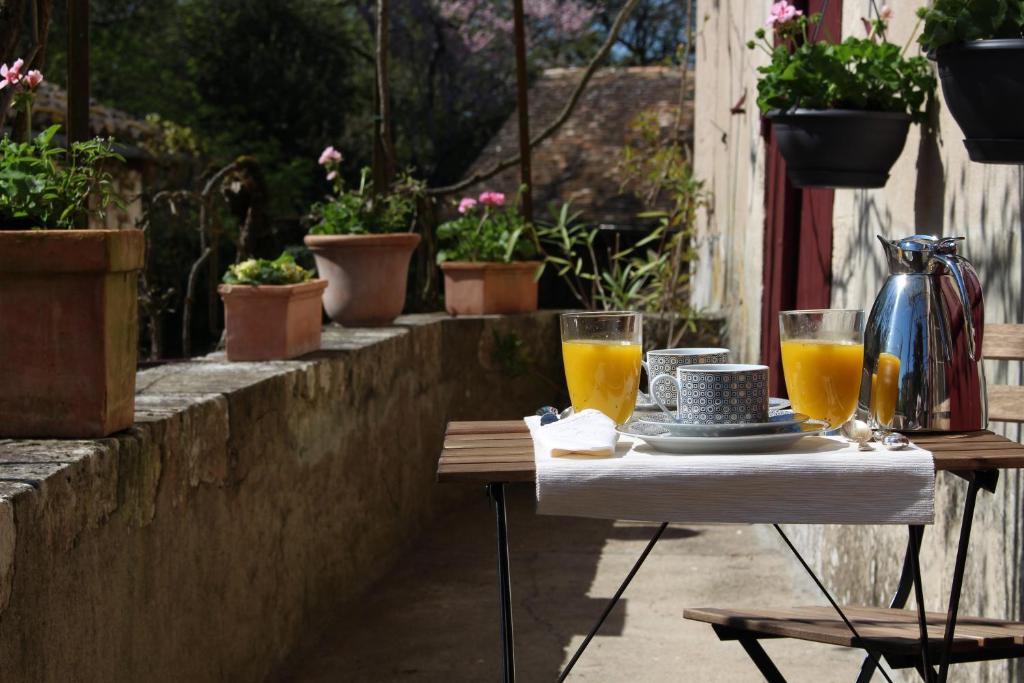 einen Tisch mit zwei Gläsern Orangensaft darauf in der Unterkunft L'Ancien Couvent Cahuzac in Cahuzac