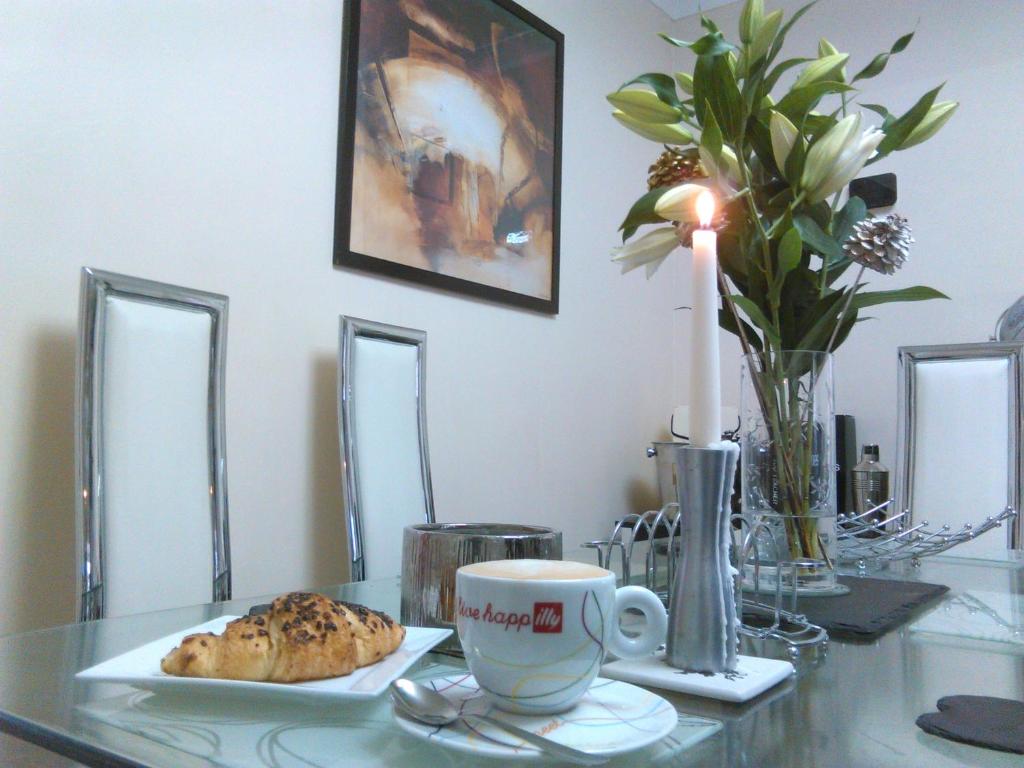 a table with a cup of coffee and a cookie at Bianca's House Hotel Heathrow Airport in Hillingdon