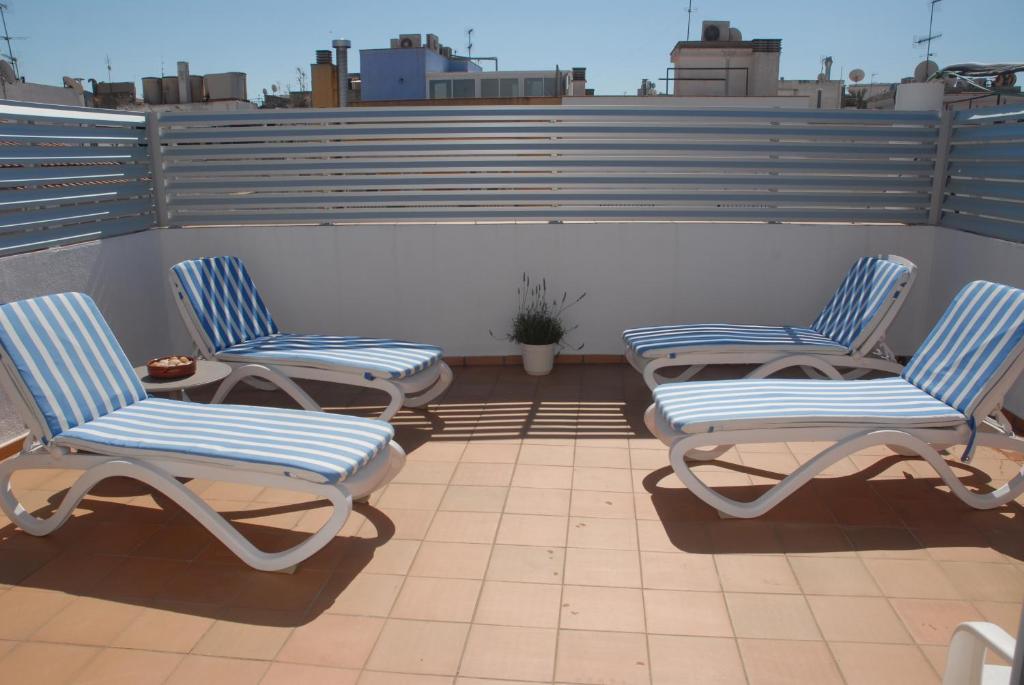 three chairs and a table on a roof at Apartaments Bonaventura 7 in Sitges