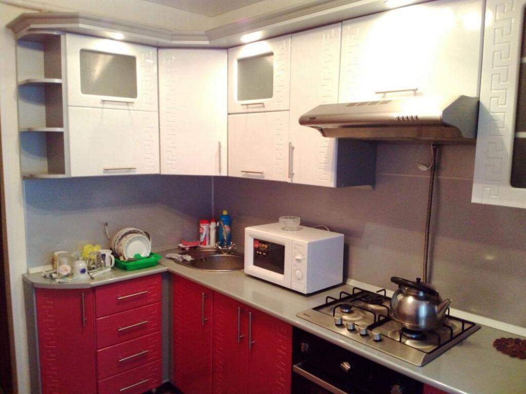 SalavatにあるАпартаменты для Троихのキッチン(赤いキャビネット、白い電子レンジ付)