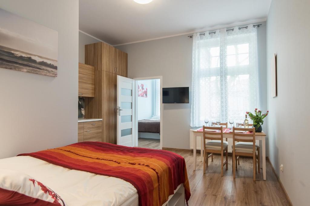 1 dormitorio con 1 cama, mesa y sillas en Sopot Host Patio en Sopot