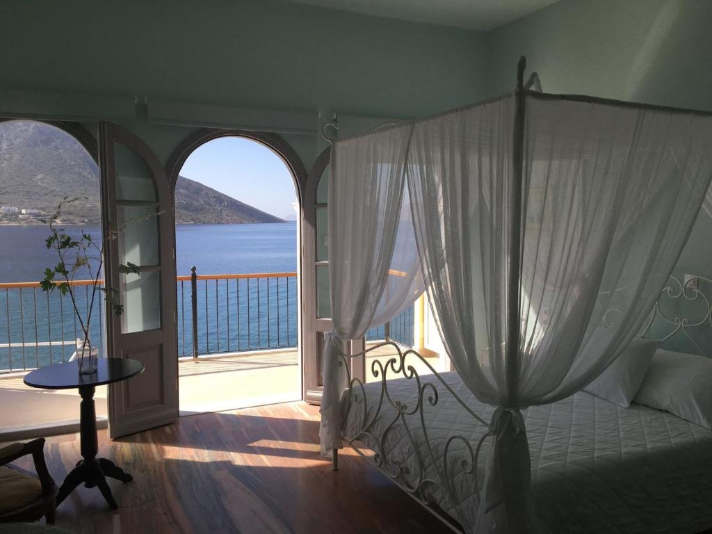 a bedroom with a bed and a view of the ocean at MasouriBlu Boutique Hotel in Masouri