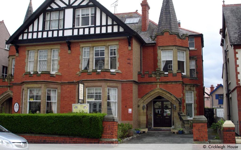 a red brick house with a black roof at Crickleigh House in Llandudno