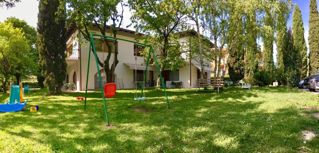 a yard with a playground in front of a house at Casa Vittoria in Nago-Torbole