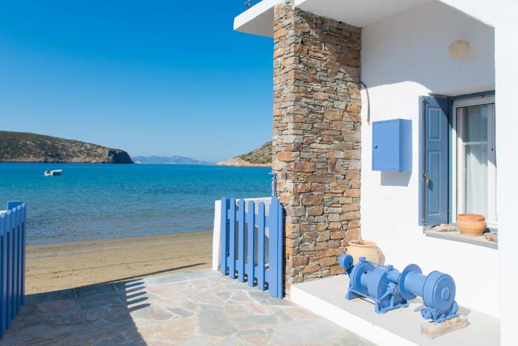 a house with a blue fire hydrant next to a beach at Aerides Boutique Rooms in Vathi