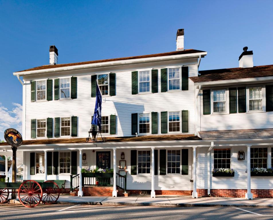 a large white building with a flag in front of it at The Griswold Inn in Essex