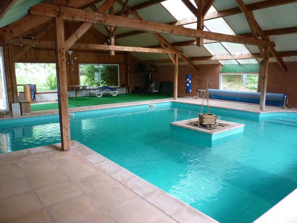 ein großer Pool mit Holzdach in der Unterkunft Beau Site Guimauve et Vieilles Dentelles in Royères-Saint-Léonard