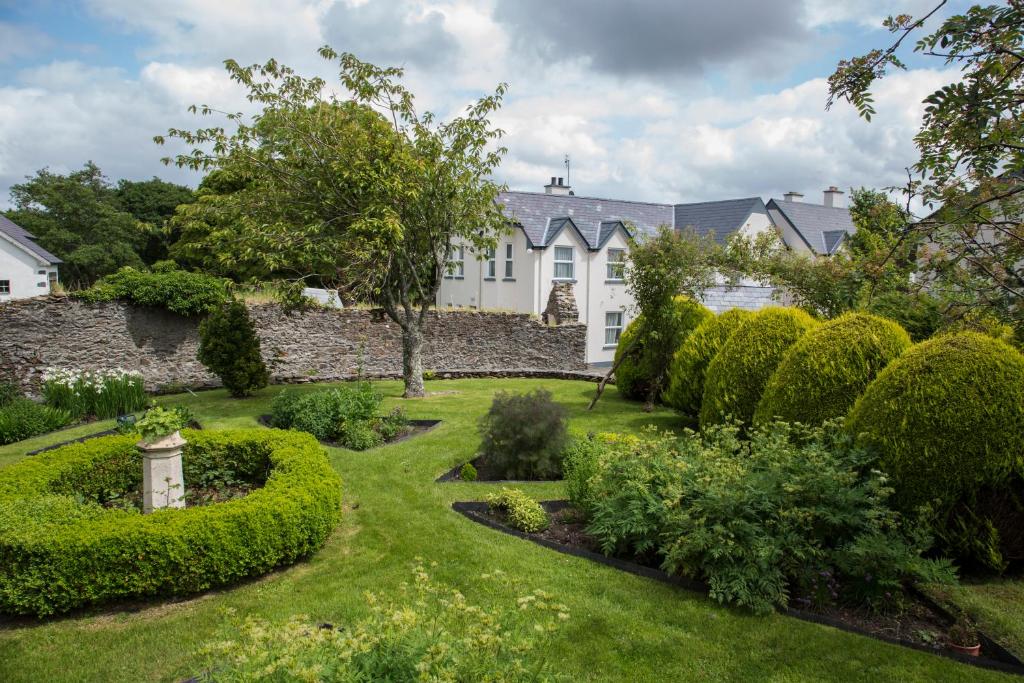 a garden in front of a white house at Woodhill House in Ardara