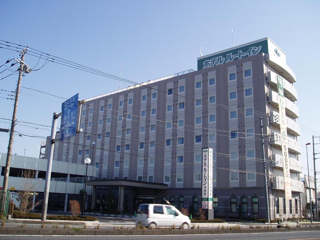 budynek z białym van zaparkowanym przed nim w obiekcie Hotel Route-Inn Sagamihara -Kokudo 129 Gou- w mieście Sagamihara