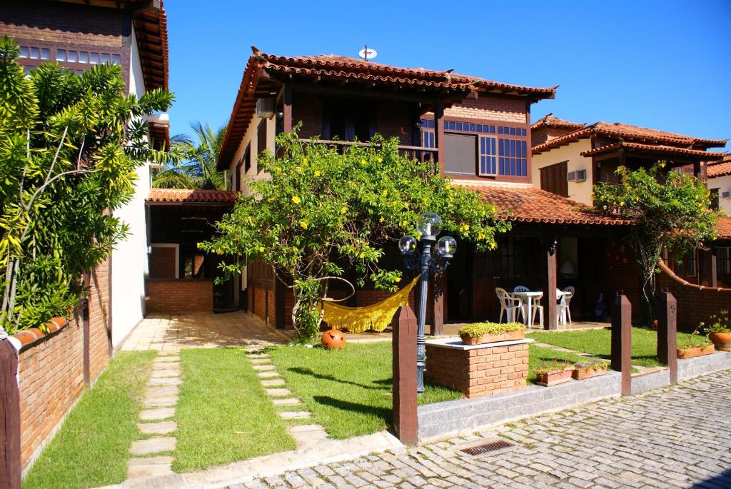 une maison avec un hamac dans la cour dans l'établissement Bela casa de 4 suítes em Geribá, à Búzios