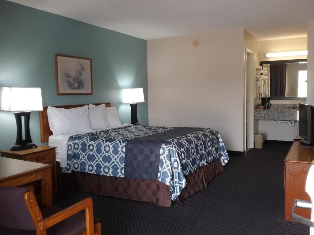 a hotel room with a bed and two lamps at Americas Best Value Inn Blue Ridge in Blue Ridge