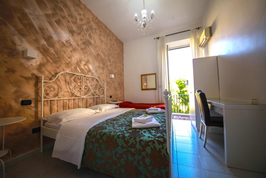 a bedroom with a bed and a desk and a window at Hotel Pisa in Rome