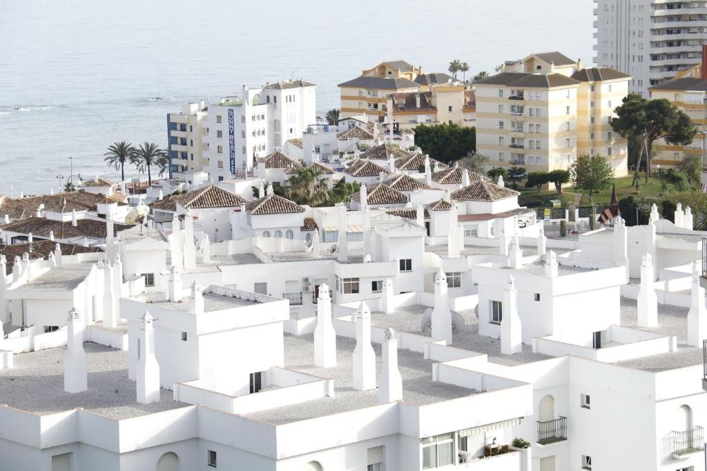a cluster of white buildings in front of the ocean at Anna & Pierre-Noel apartment. in Benalmádena