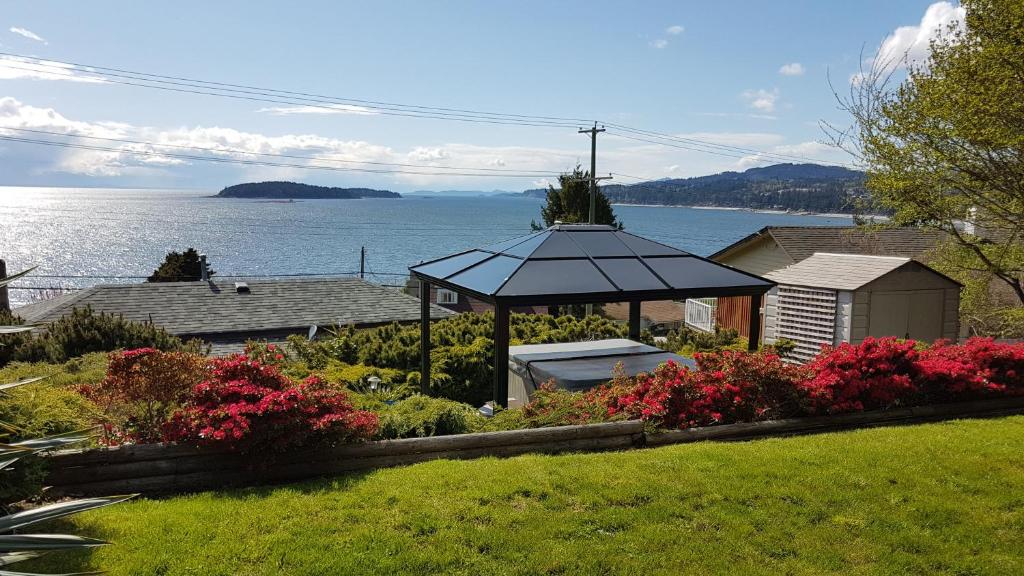 un cenador en un patio junto al agua en Blue Waters Cottage en Sechelt