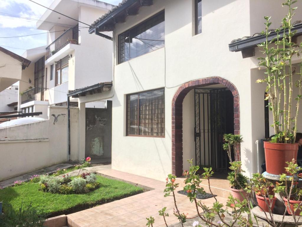 a white house with a courtyard with plants at Quito Kawsay in Quito