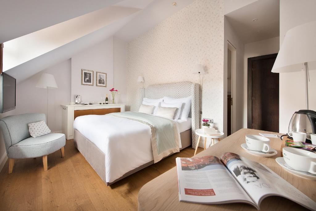 a bedroom with a bed and a table with a book at Design Hotel Neruda in Prague