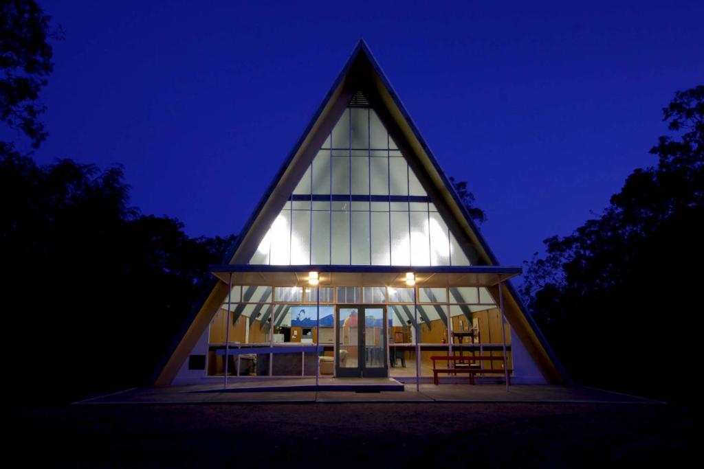 um edifício de igreja com um telhado triangular à noite em The Abbey Raymond Island em Raymond Island