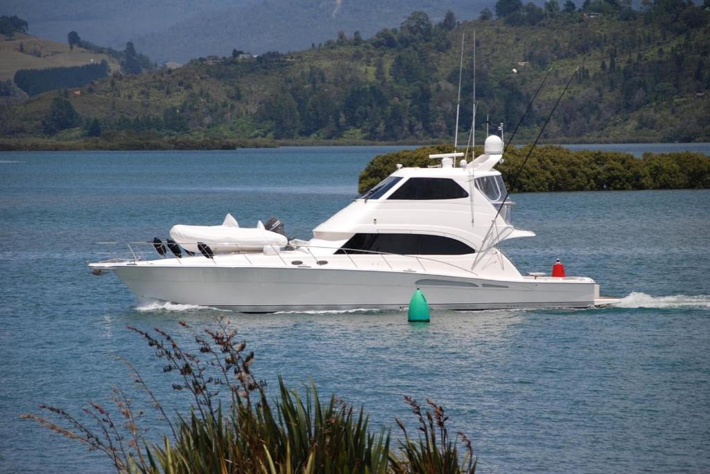 a white boat on a body of water at Tides Reach Whitianga in Whitianga