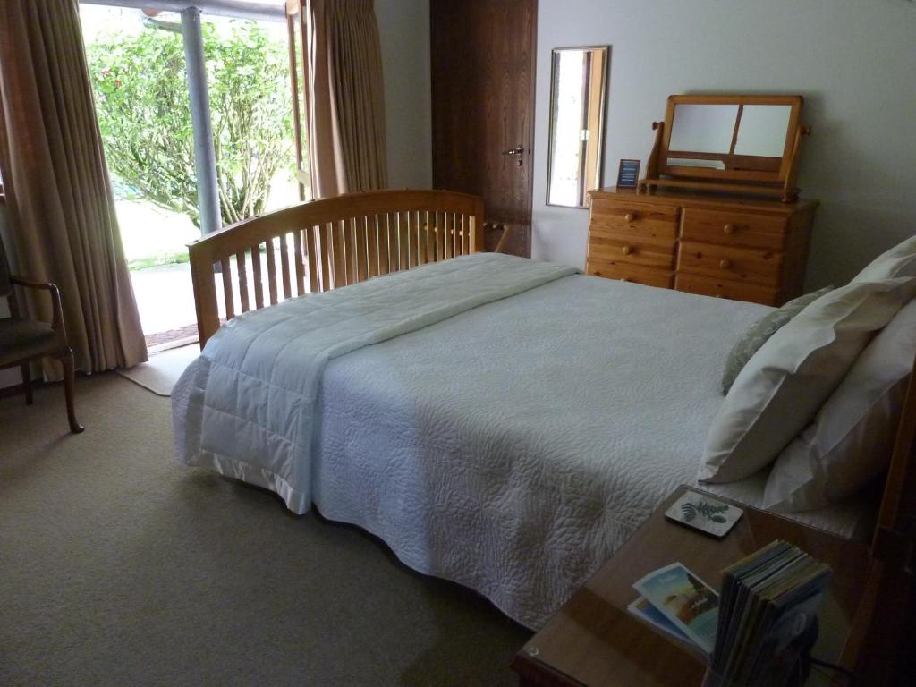 um quarto com uma cama, uma cómoda e uma janela em Thorold Country House em Thames