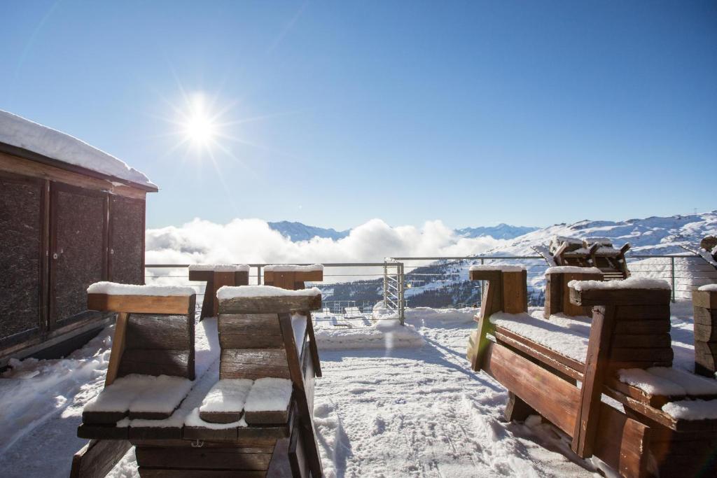 a picnic table and chairs in the middle of a snow covered field at Berghaus Nagens in Flims