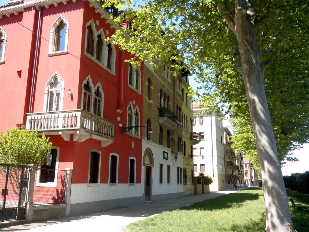 un edificio rosso con balcone su una strada di Maison Sant'Elena a Venezia