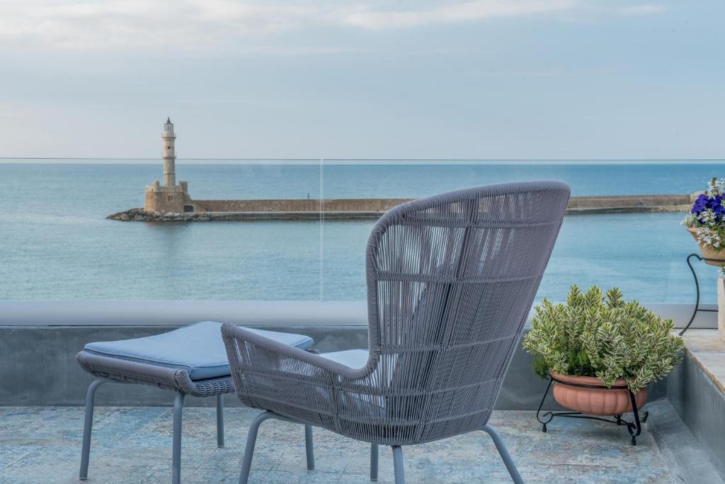 un paio di sedie sedute su un balcone con vista sull'oceano di Residenza Vranas Boutique Hotel a Chania