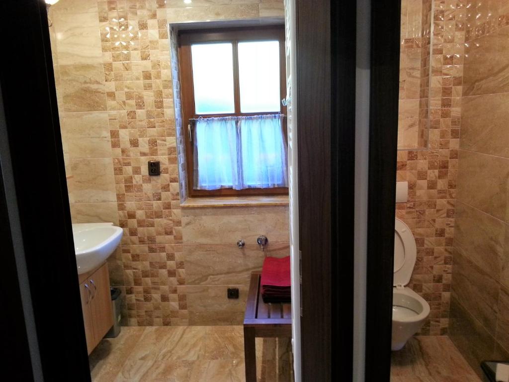 łazienka z toaletą, umywalką i oknem w obiekcie Ubytování Steak-Hredle w mieście Hředle