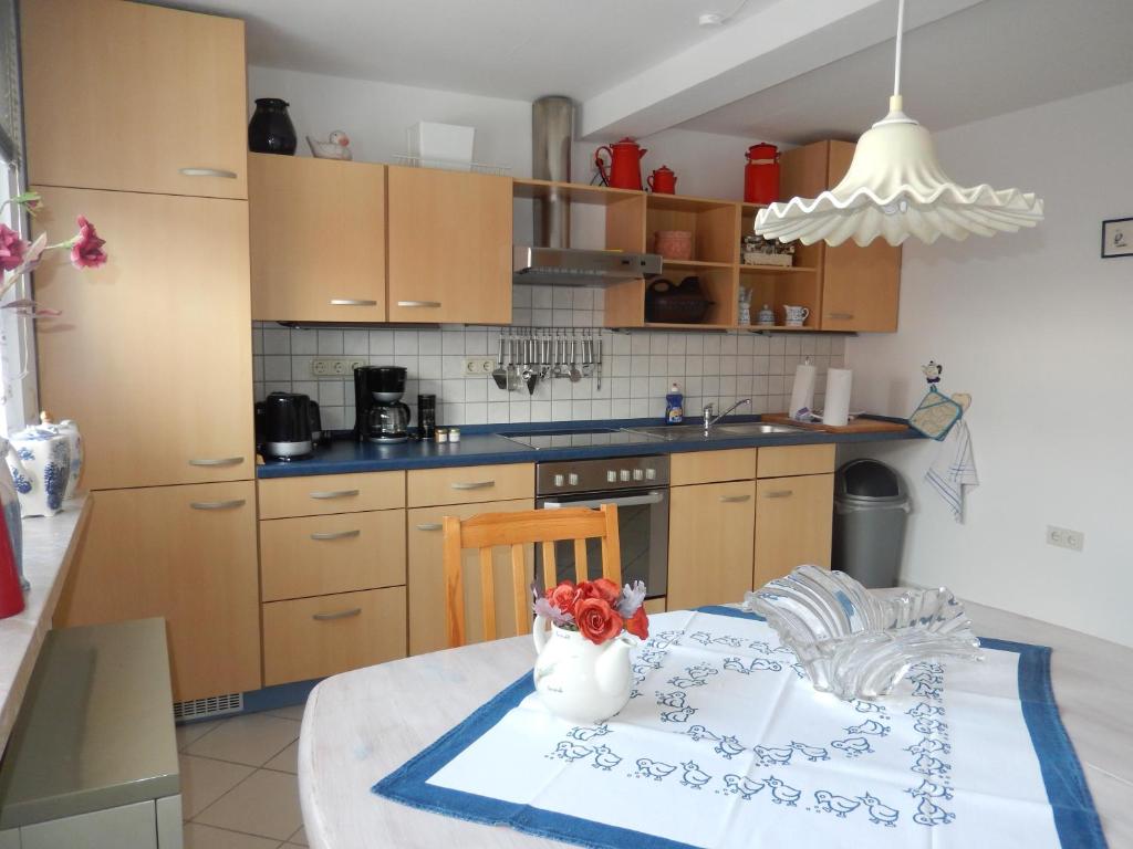 a kitchen with a table with a vase of flowers on it at Ferienwohnung Ebeling under stars in Dassel