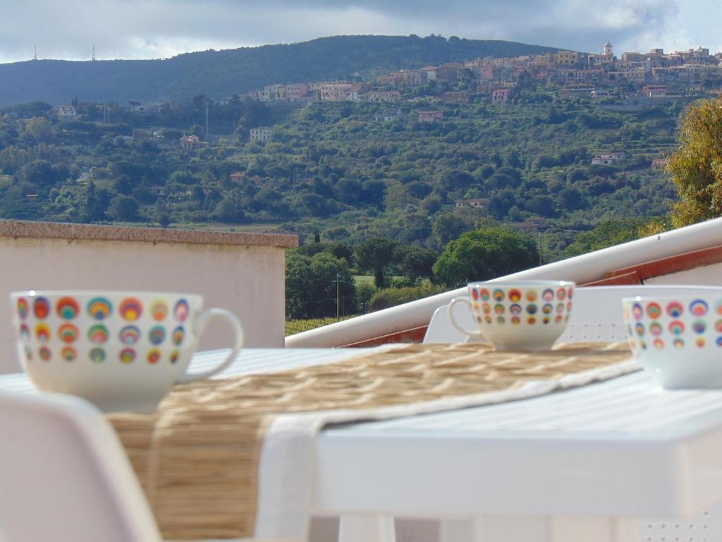 カポリーヴェリにあるAppartamenti Gli Alberiの- バルコニーのテーブルに座ったコーヒーカップ2杯