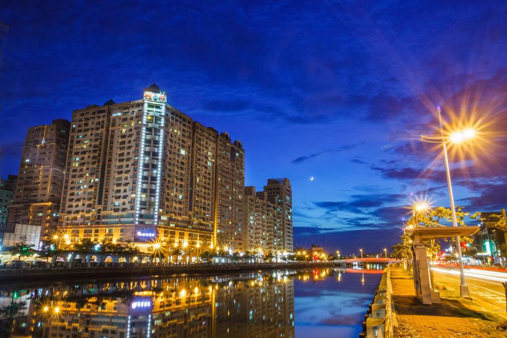 un edificio alto por la noche junto a un río en Wei-Yat Grand Hotel, en Anping