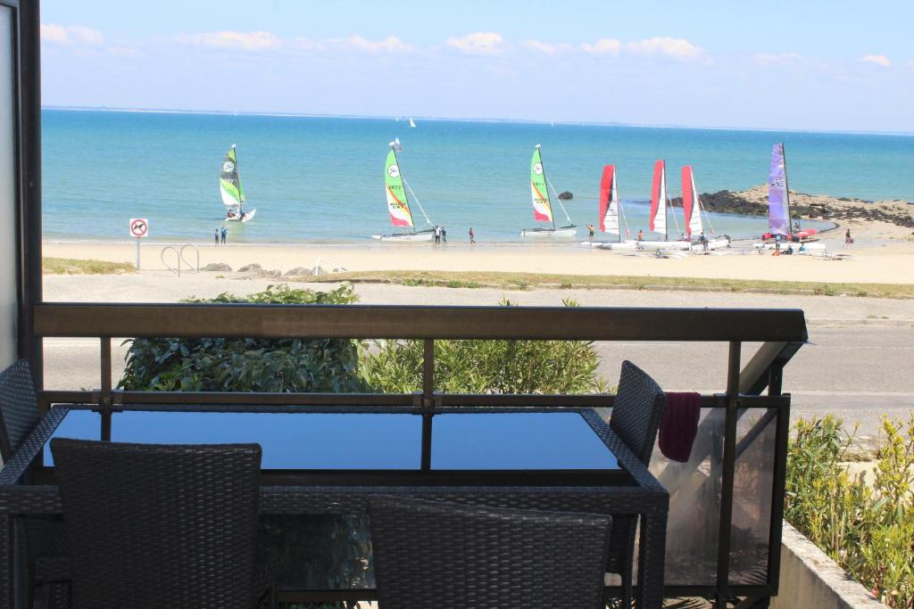 - une table avec vue sur une plage avec des voiliers dans l'établissement Nicolas Lambert - Appartement vue mer, prêt de velos,WIFI, à Quiberon