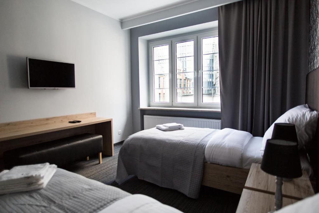 pokój hotelowy z dwoma łóżkami i oknem w obiekcie Szczęśliwa 13 w Poznaniu