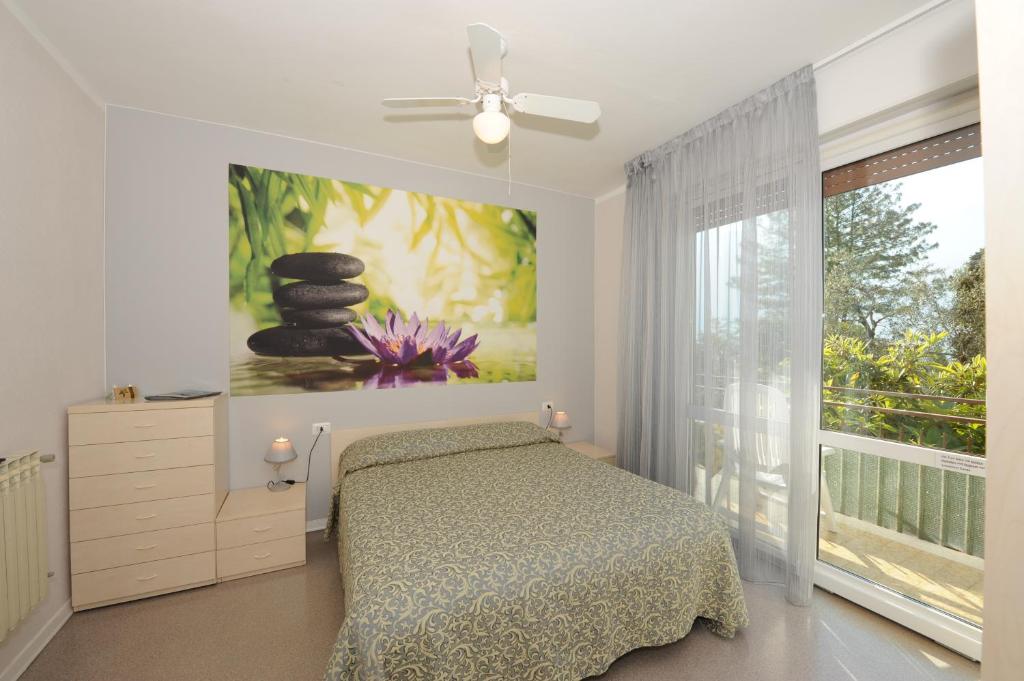 - une chambre avec un lit et une fenêtre ornée d'un tableau dans l'établissement Hotel Villa Grazia, à Limone sul Garda