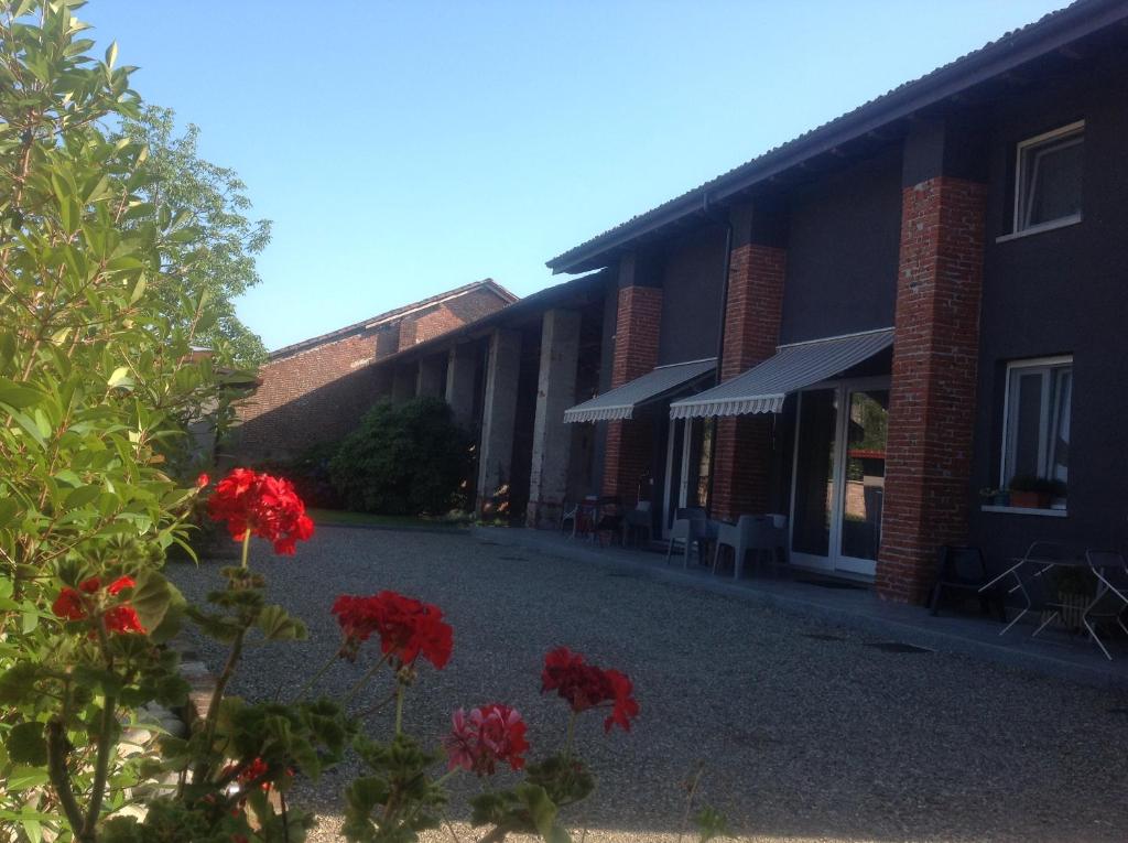 una fila de edificios con flores rojas en el patio en Residence Campagnole en Vicolungo