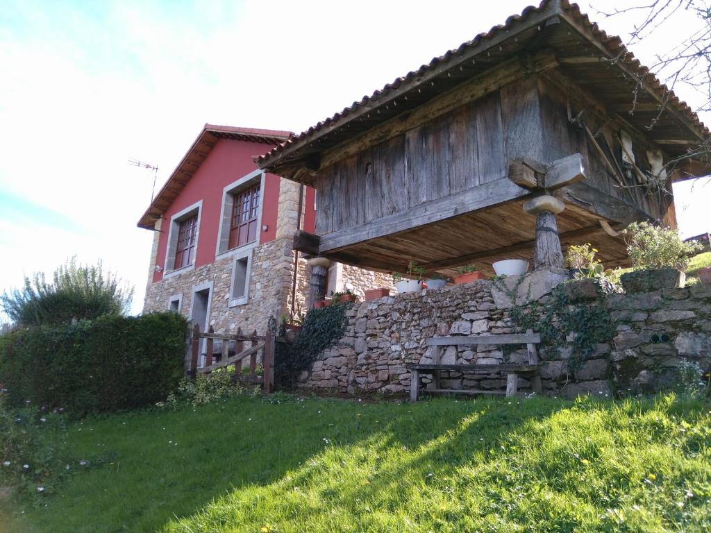 a house with a stone wall and a fence at Casa Rural La Cuesta in Villarmil