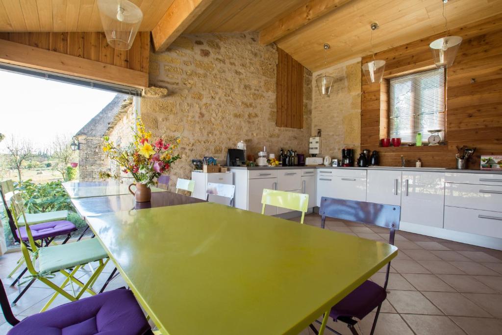 cocina con mesa verde y sillas en Chambres d'Hôtes L'Oustralac, en La Chapelle-Aubareil