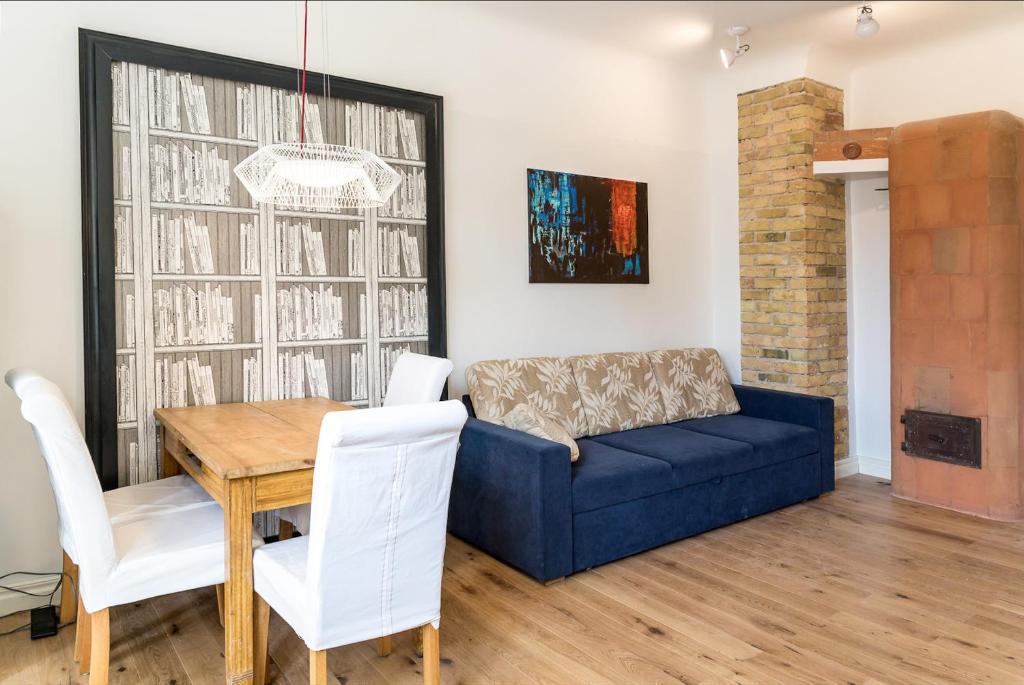 a living room with a blue couch and a table at Aia Vacation Apartment in Pärnu