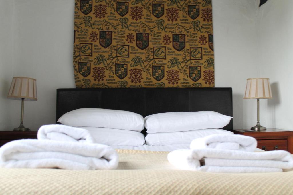 a room with a bed with towels on it at Old Court Hotel & Apartments in Symonds Yat