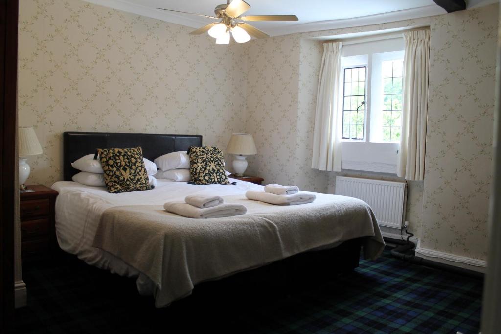 a bedroom with a bed with two towels on it at Old Court Hotel & Apartments in Symonds Yat