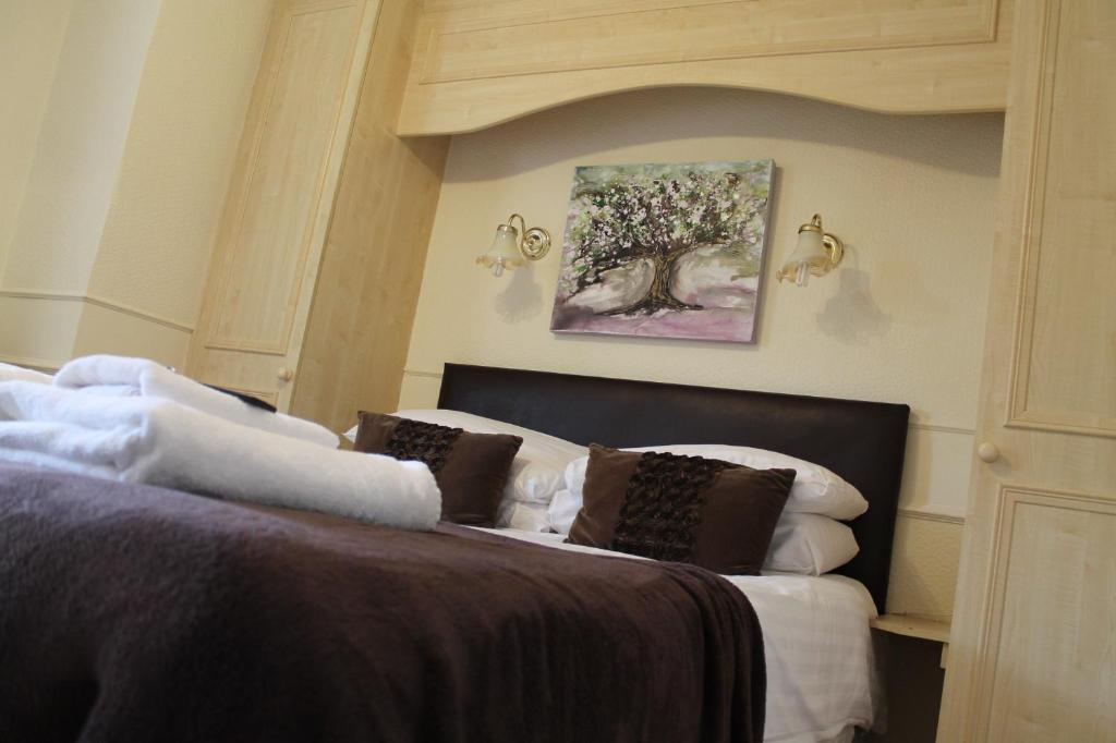 a bedroom with a bed and a painting on the wall at Old Court Hotel & Apartments in Symonds Yat