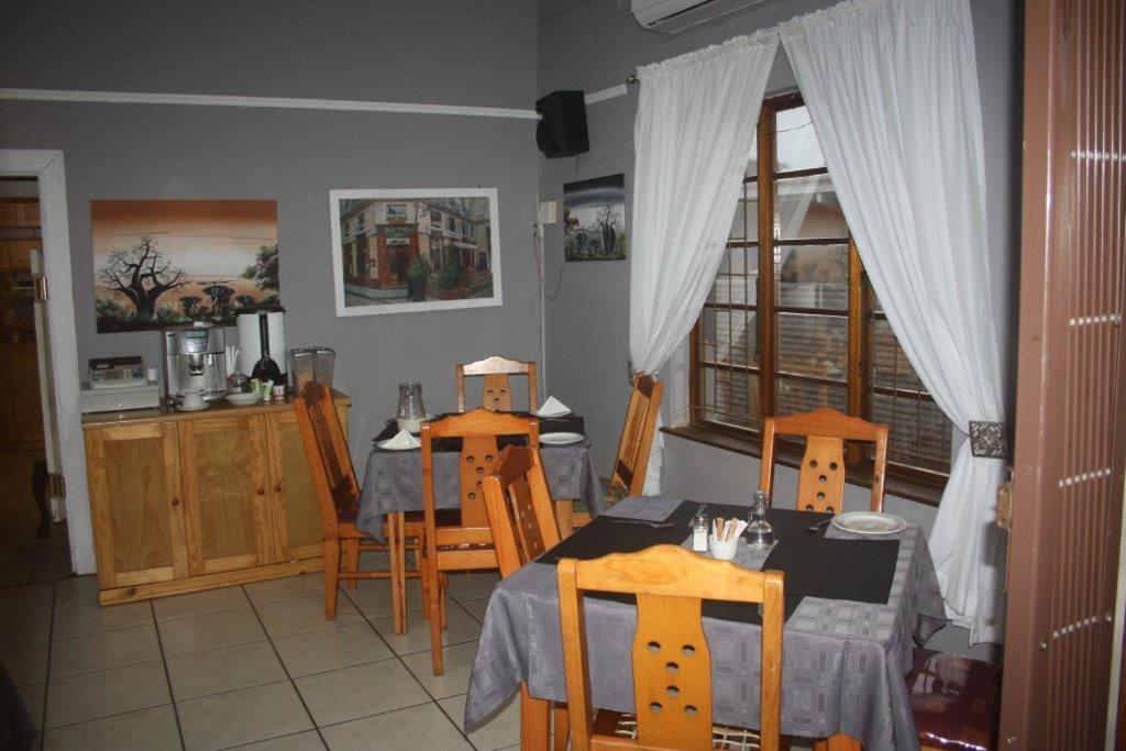 uma cozinha e sala de jantar com mesa e cadeiras em Eagles Nest Guesthouse em Eshowe