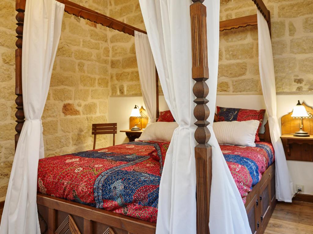 a bedroom with two beds and a canopy bed at Helios Garden Boutique Apartments in Rhodes Town