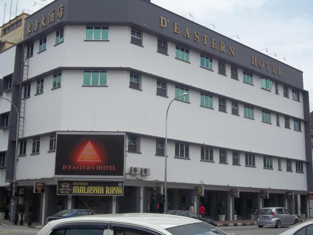 um grande edifício branco com um cartaz em D Eastern Hotel em Ipoh