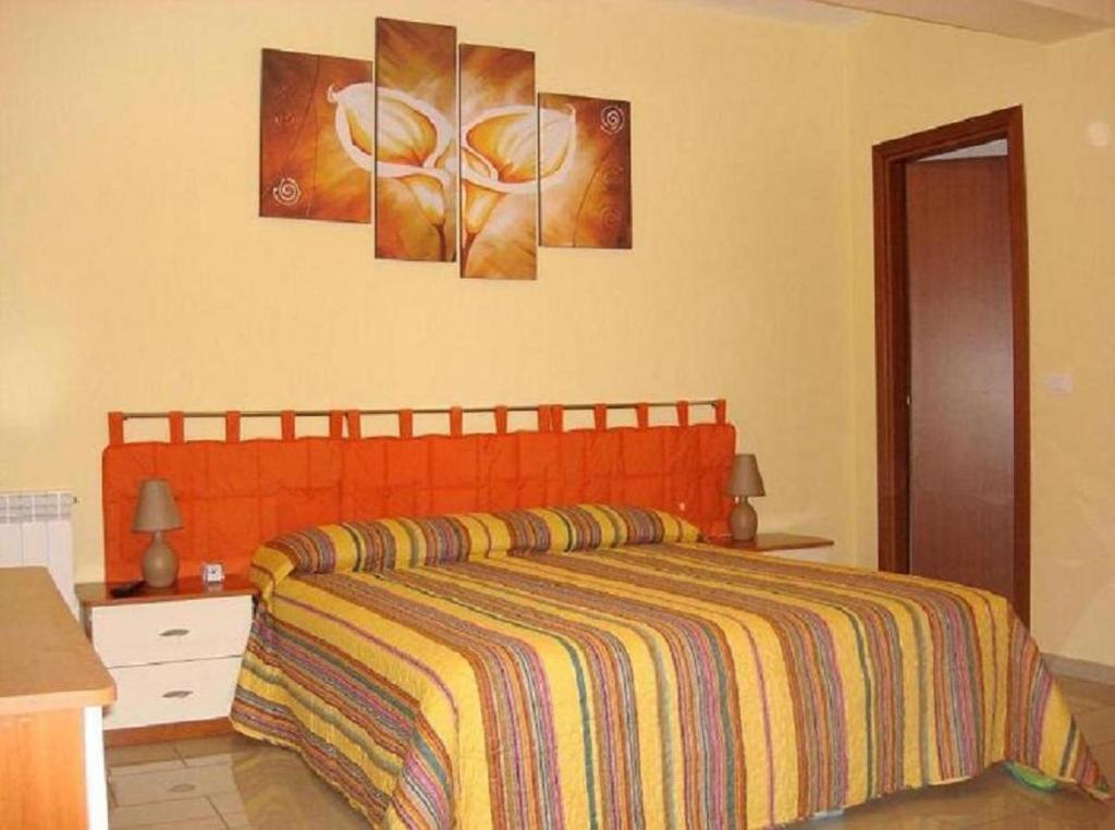 a bedroom with a bed and three paintings on the wall at B&B Il Gabbiano in Reggio di Calabria