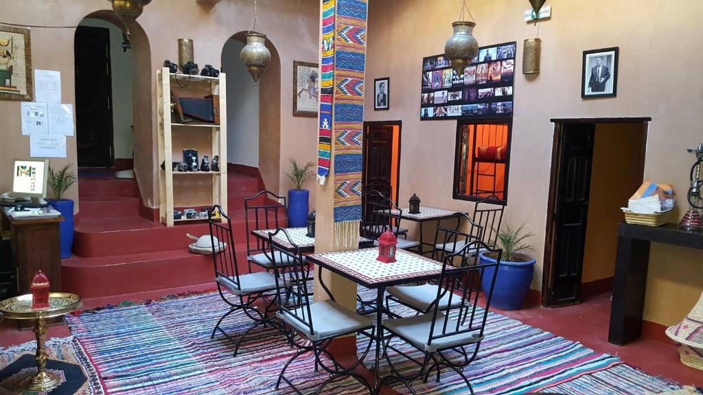 a restaurant with tables and chairs in a room at Cinema Riad in Ouarzazate