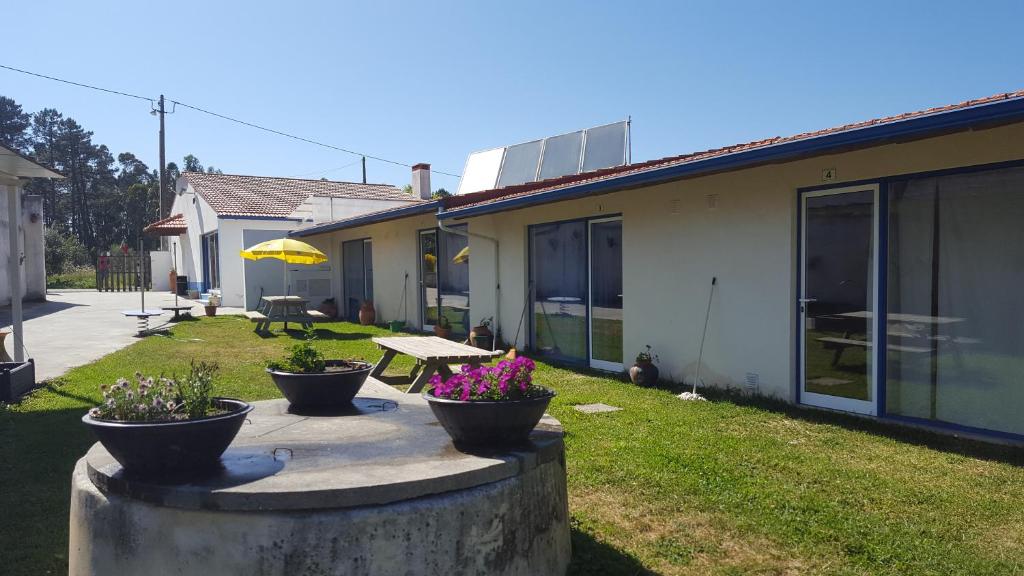 a patio with three potted plants and a picnic table at Quinta do Valão in Marinha Grande