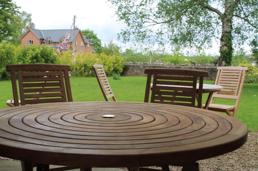 a wooden table with two chairs and a table and chairs at Old Court Hotel & Apartments in Symonds Yat