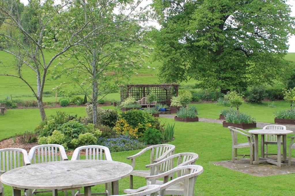 a group of tables and chairs in a garden at Old Court Hotel & Apartments in Symonds Yat