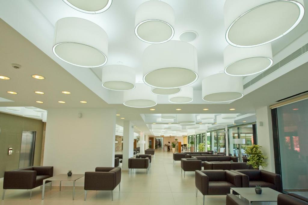 a hospital lobby with chairs and a ceiling with circles at Alimounda Mare Hotel in Karpathos